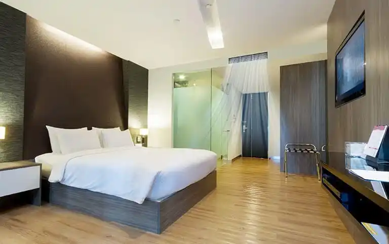 Modern hotel room with centralized air conditioning vents above the entrance, illustrating a concealed AC system for hotel and resort comfort.