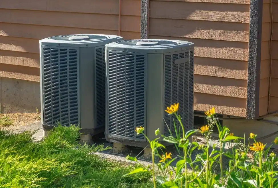 Outdoor HVAC systems surrounded by vegetation, potentially affected by environmental factors when HVAC stops working suddenly.