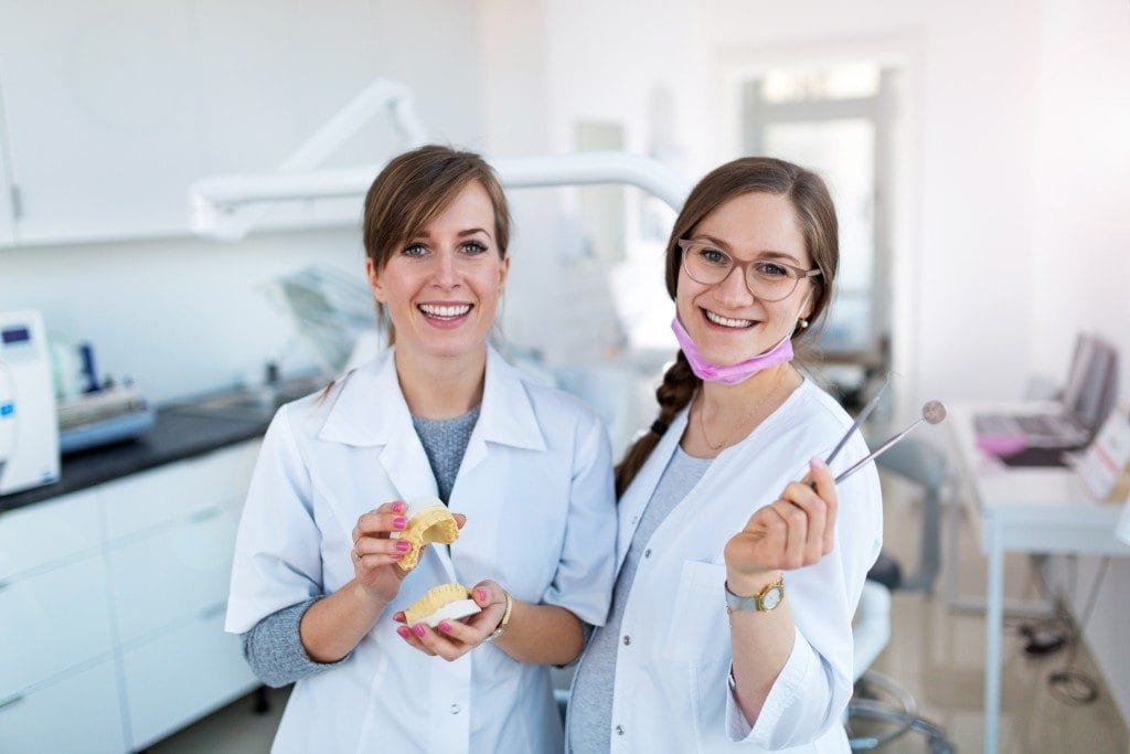 Two dentists are happy to market their dental practice.